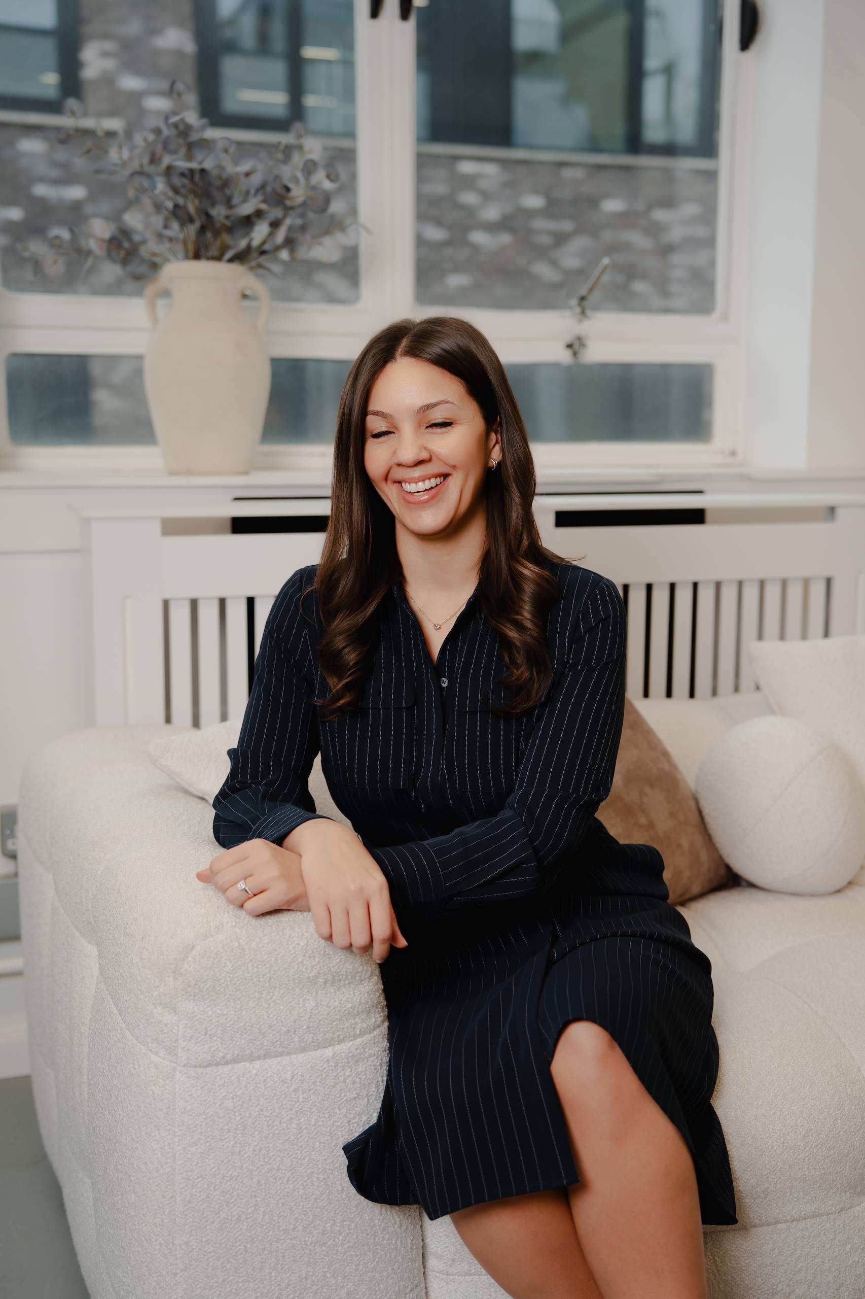 Dominique Hendrickson-Gerrick seated in an armchair, wearing a dark dress.